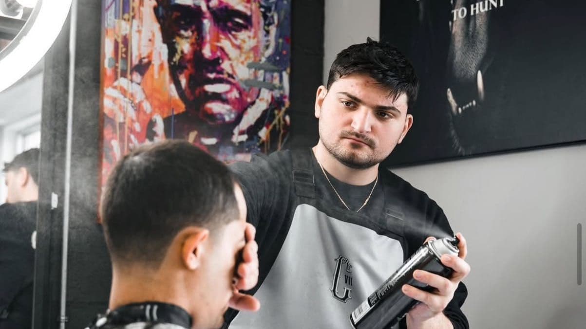 Barber shaping a low fade at Colella Cutz Barber Studios