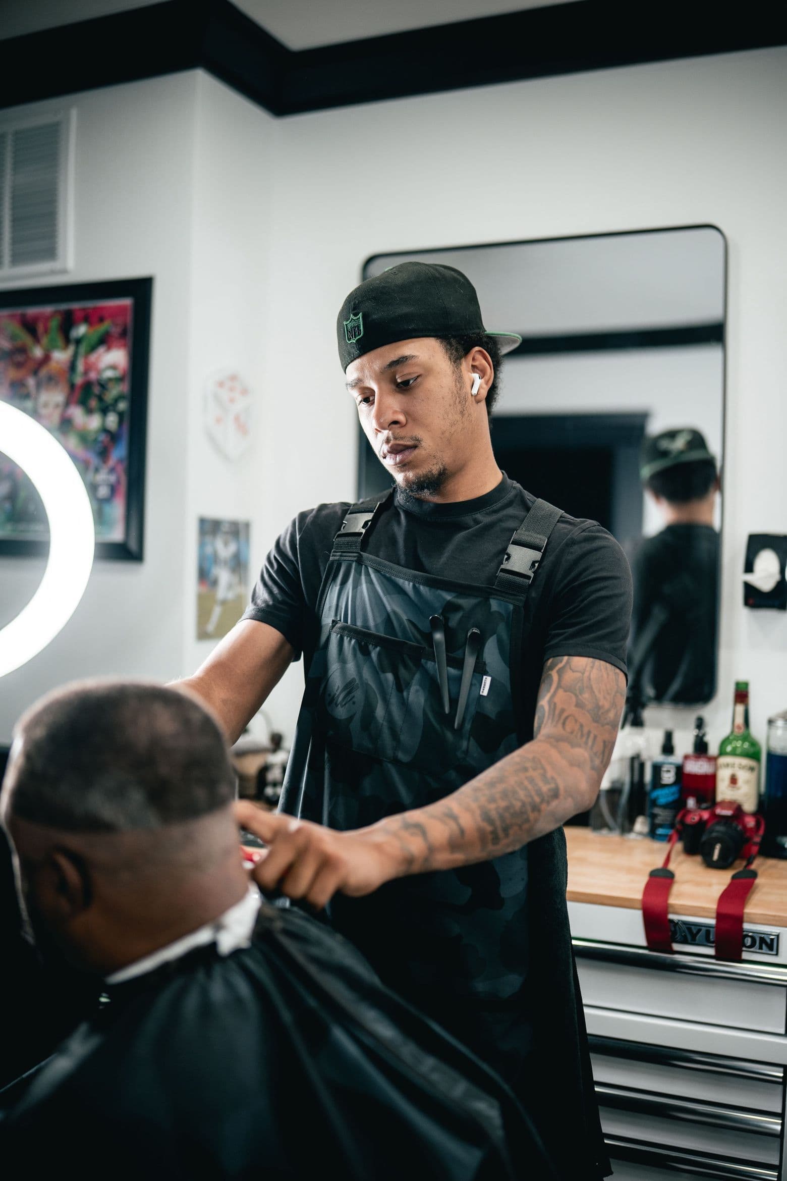 Barber finishing a taper fade at Colella Cutz